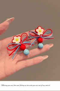 Détail de barrettes à nœuds colorés avec fleur centrale en rouge et bleu vif