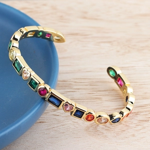 Detail of gold open bracelet featuring multicolored heart and square zircon stones
