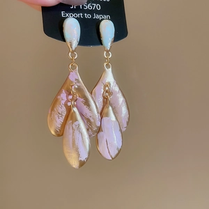 Detail of elegant two-tone heart pendant earrings with pink and blue enamel on black card