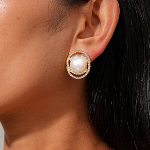 Detail of round pearl stud earring with double rhinestone halo on model ear