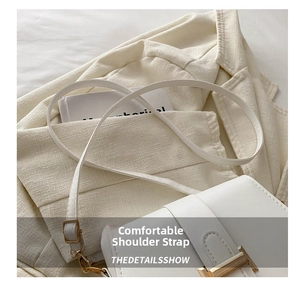 Detail showing the adjustable white leather shoulder strap and golden metal buckle of the bag