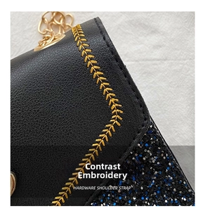 Detail of golden wheat embroidery on black leather and blue sequins with chain strap