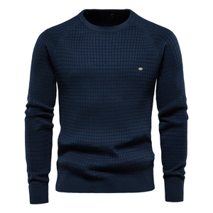Gros plan détaillé sur la maille gaufrée bleu marine d'un pull pour homme à col rond