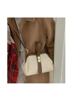 Retro cream crossbody bag with brown leather trim and gold metal clasp shown on model