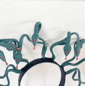 Detail of dark green Medusa headband with red-eyed snake accents for cosplay costume