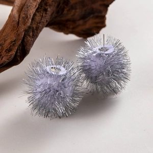 Nahaufnahme der fliederfarbenen Weihnachts-Pompon-Ohrringe mit silbernen Glitzerfäden