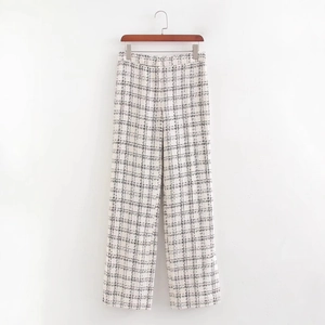 Elegant black and white plaid tweed sleeveless vest and trousers set on a wooden hanger