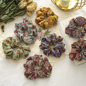 Close-up of seven assorted floral fabric scrunchies with vintage French style decor