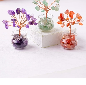 Detailed view of three mini crystal trees in purple, green and orange with glass pots