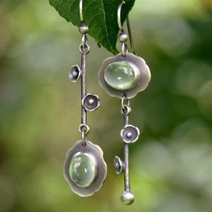 Vintage zilveren asymmetrische oorbellen met groene edelsteen en bloemmotief