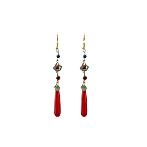 Detail of red teardrop earrings with golden cloud motif and vintage beads