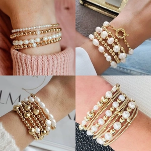 Detail of layered gold bead and white pearl bracelets worn by a model in lifestyle scenes