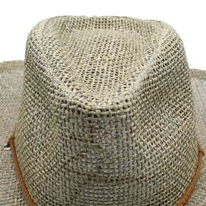 Detailed close-up of handmade woven straw cowboy hat with intricate cross-weave texture