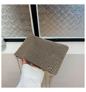 Macro detail of sparkling gold rhinestone mesh handbag with premium metal chain strap