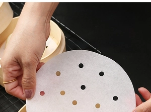 Detail of round non-stick steamer paper with air holes for bamboo baskets