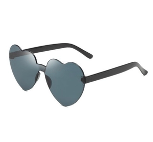 Detailed close-up of trendy heart-shaped sunglasses with dark gray lenses and black frames