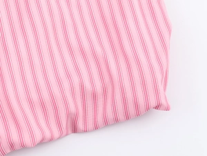 Dettaglio del tessuto a righe rosa e bianche con morbide pieghe di cotone naturale