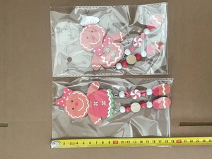 Detailed view of two wooden gingerbread man Christmas ornaments with measuring tape