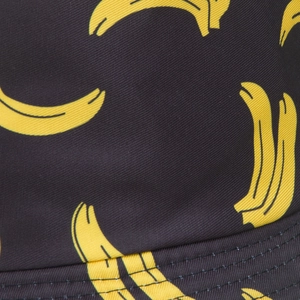 Vue détaillée du tissu sergé noir avec imprimé bananes et coutures doubles précises