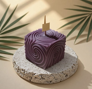 Purple cube aromatherapy candle with spiral swirl texture on a stone base decor