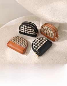 Close-up of houndstooth canvas coin purses with leather patchwork and double zippers