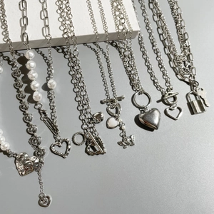 Set of silver necklaces featuring butterfly, heart pendants and pearls on stone decor