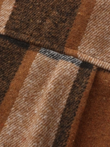 Dettaglio macro della trama in tessuto a quadri marrone e beige per camicia uomo