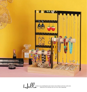 Macro detail of black metal jewelry organizer with wooden base and necklace hooks