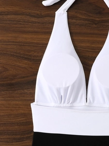 Dettaglio del costume da bagno bianco e nero con scollo a V, imbottitura e lacci