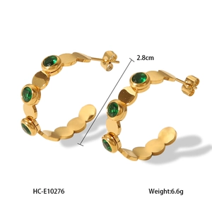 Detail view of 18K gold stainless steel C-shaped earrings with five green inlaid stones
