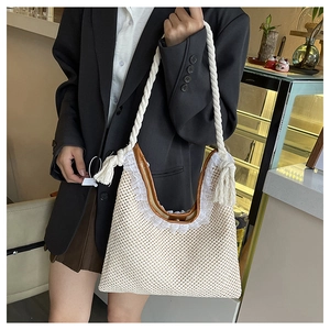 Close-up of cream woven handbag featuring white lace trim and brown leather handles