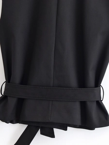Détail de la taille du gilet noir sans manches avec ceinture assortie et coutures soignées
