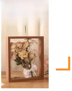 Detail of wooden shadow box frame with dried roses and a Best Wishes ribbon on wood