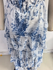Detail of blue floral chiffon dress showing tiered ruffle hem and cinched waistline