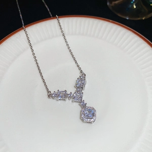Dettaglio del ciondolo della collana in zircone quadrato su un piatto bianco