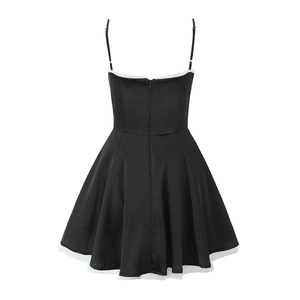 Détail du dos de la robe en satin noir avec zip, dentelle blanche et ourlet étagé