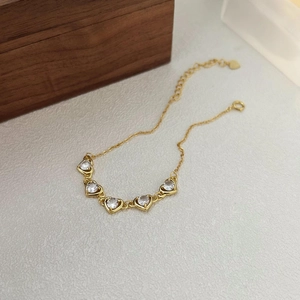Elegant gold S925 silver bracelet featuring five heart-shaped clear cubic zirconia gems
