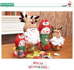 Close-up of Santa and Snowman Christmas candy jars with knitted caps on a wooden table