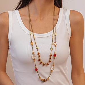 Detail of bohemian double-layer necklace with colorful resin beads and gold chain