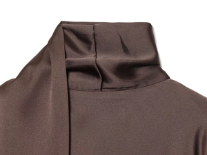 Détail d'une robe en satin marron chocolat montrant le col haut et le tissu plissé