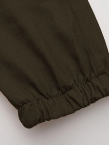 Detail of olive green cargo pants showing elastic ribbed cuffs and twill fabric texture