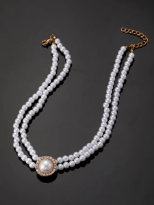 Close-up of double-layer white pearl necklace with rhinestone pendant on black background