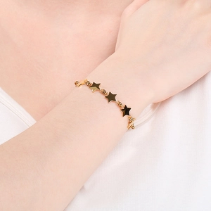 Close-up of a stylish gold star link bracelet worn on wrist for a minimalist look