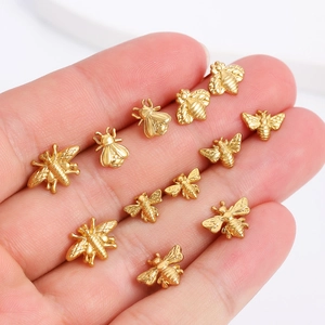 Golden honeybee stud earrings displayed on palm showing detailed wings and diverse poses