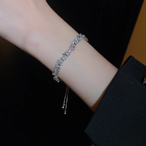 Detailed view of silver butterfly bracelet with pearls and crystals on a dark background