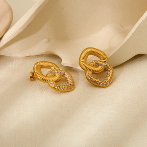 Detail of gold double loop earrings featuring a twisted metal ring and pavé cubic zirconia