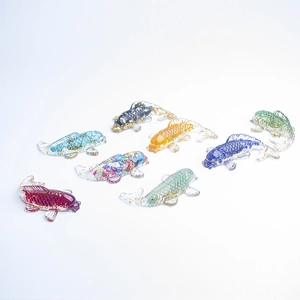 Ensemble de huit figurines de carpes koï en résine colorée avec feuilles d'or sur fond blanc