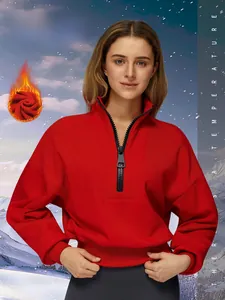 Macro detail of red quarter-zip sports sweatshirt with warm fleece lining and ribbed cuffs