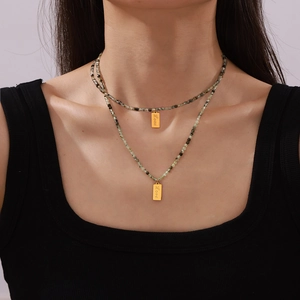 Double-layer beaded necklace with peridot green stones and gold love tag pendants