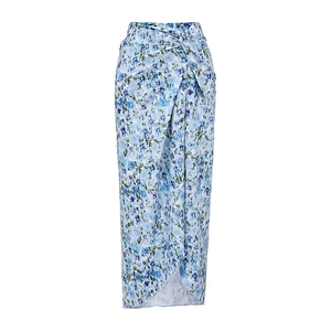 Detail of high-waisted wrap skirt with sky blue floral print and draped asymmetrical hem
